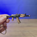3D-printed AKS-74U rifle keyring shown being held and rotated by hand, designed as a miniature FPS-inspired accessory or gamer gift.