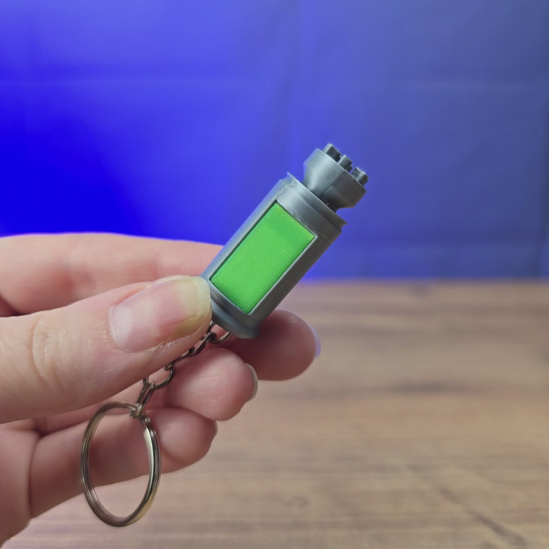 3D-printed Factorio nuclear keyring shown being held and rotated by hand, with a compact game-inspired design and keychain loop.