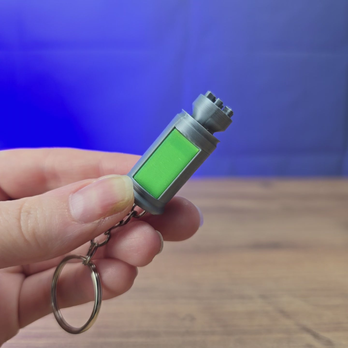 3D-printed Factorio nuclear keyring shown being held and rotated by hand, with a compact game-inspired design and keychain loop.