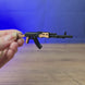 AK-74 rifle keyring shown being held and rotated by hand, designed as a miniature rifle-inspired gamer accessory or keychain.