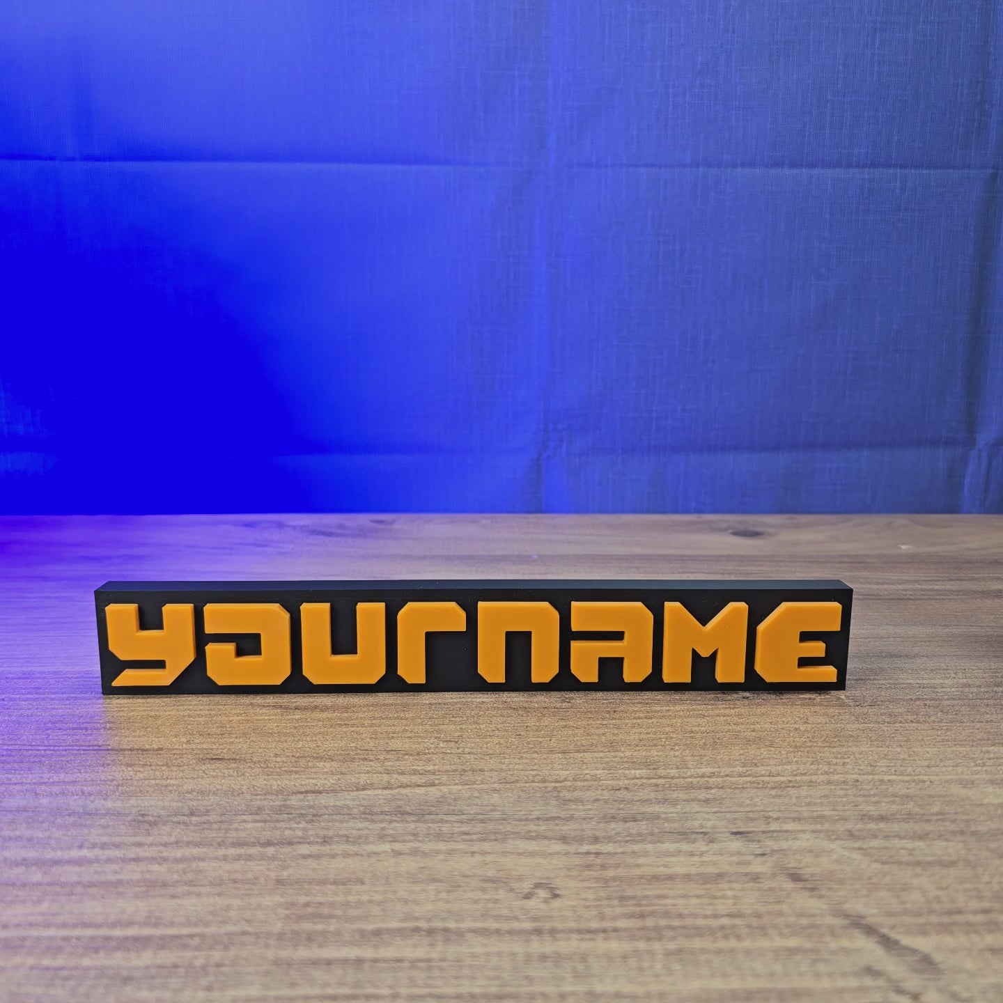 3D-printed Factorio logo display sign with raised orange letters on a black base, shown from multiple angles.
