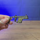 3D-printed KRISS Vector Gen 2 SMG keychain shown being held and rotated by hand, designed as a miniature SMG-inspired accessory or keyring.