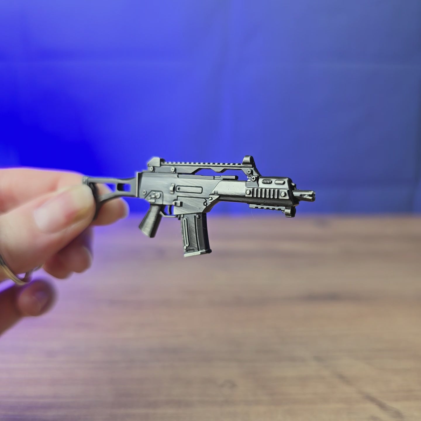 3D-printed HK G36 rifle keyring shown being held and rotated by hand, designed as a miniature rifle-inspired accessory or keychain.