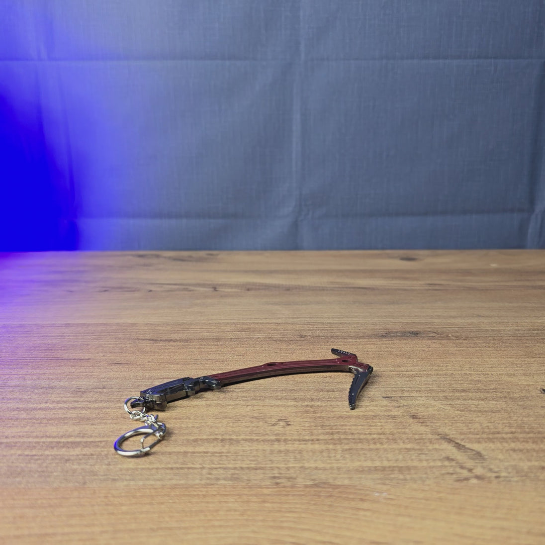 Red Rebel ice pick keyring shown being held and rotated by hand, designed as an Escape from Tarkov-inspired gaming accessory, collectible, or fan gift.