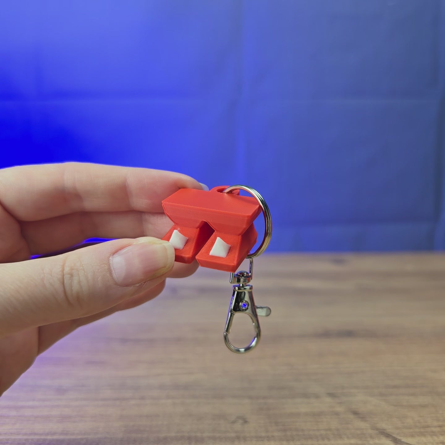 3D-printed Old School RuneScape Dragon Boots keyring shown being held and rotated by hand, designed as an OSRS-inspired accessory for fans and players.