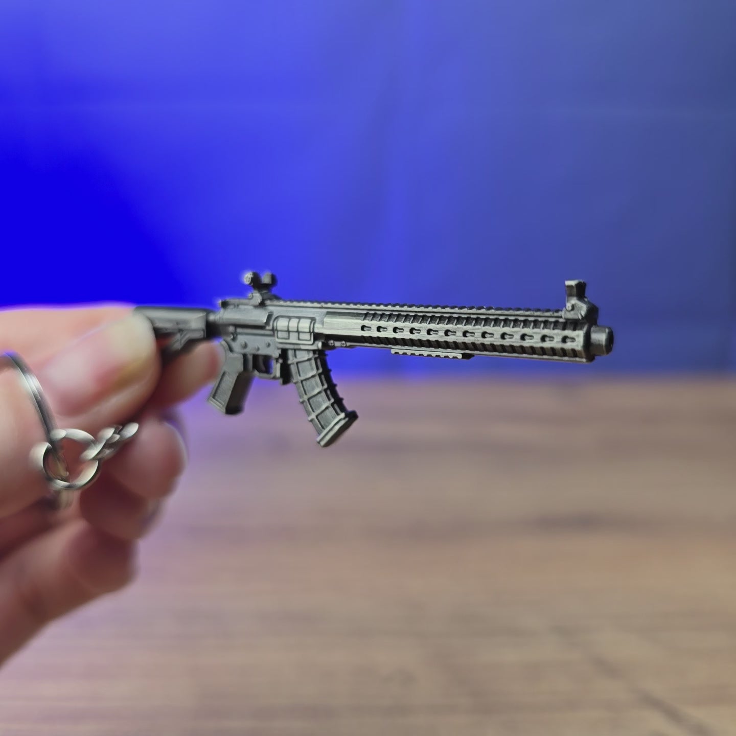 MK47 rifle keyring shown being held and rotated by hand, designed as a miniature rifle-inspired accessory or keychain.
