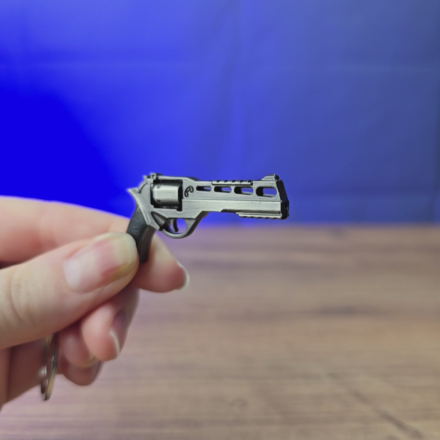 Chiappa Rhino mini revolver keyring shown being held and rotated by hand, designed as a miniature revolver-inspired accessory or keychain.