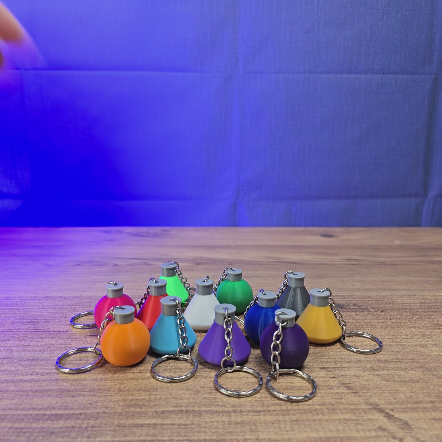 3D-printed Factorio flask keyring shown being held and rotated by hand, with a compact flask-shaped design and keychain loop.