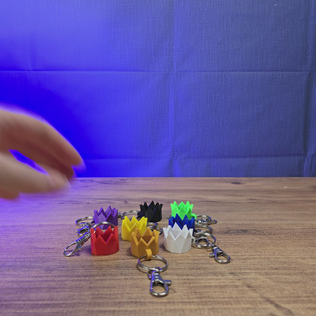 3D-printed Old School RuneScape party hat keyring shown being held and rotated by hand, designed as a game-inspired accessory for OSRS fans.