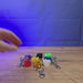 3D-printed Old School RuneScape party hat keyring shown being held and rotated by hand, designed as a game-inspired accessory for OSRS fans.