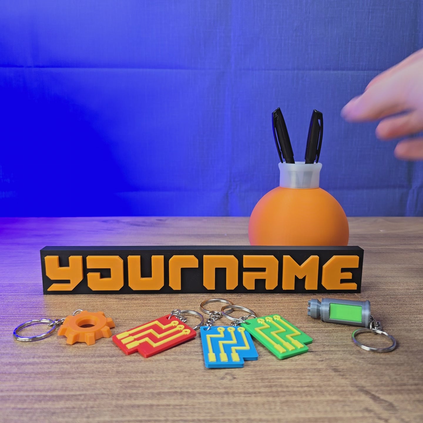 Factorio-inspired 3D-printed gift bundle with a logo nameplate, flask pen pot, and keyring, shown being handled and displayed together.
