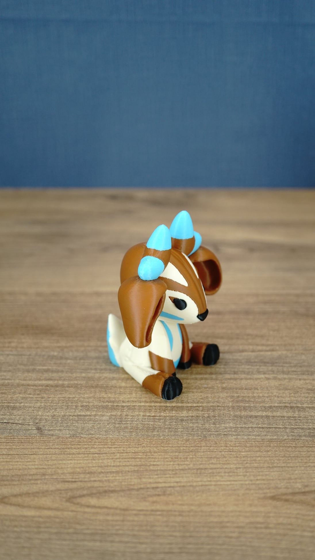 Side view of the Proudhorned Sernuk-inspired plush figure showing cream body details and seated pose.