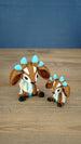 Proudhorned Sernuk-inspired Palia plush figure with cream and brown body, blue horn accents, and black hooves.