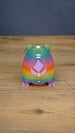 Back view of a rainbow Frogbert plush figure showing purple back details, white markings, and colorful gradient body.