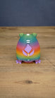 Back view of a rainbow Frogbert plush figure showing purple back details, white markings, and colorful gradient body.