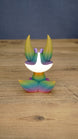 Back view of a rainbow Kitsuu figure showing its large ears, white head marking, and gradient tail colors.