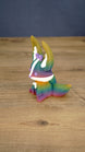 Side view of a rainbow Kitsuu figure showing its tall ears, curved tail, white face stripe, and multicolor 3D printed finish.
