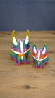 Large and small rainbow Kitsuu figures displayed together on a wooden tabletop.