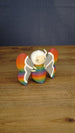 Angled side view of the Palia-inspired Rainbow-Tipped Butterfly figure showing its colourful body, layered wings, antennae and small beige legs.