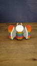 Back view of the Rainbow-Tipped Butterfly Plush figure displaying its symmetrical rainbow wing tips, grey inner wings and rounded multicoloured body.