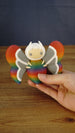 Hand holding the large Rainbow-Tipped Butterfly Plush figure to show its approximate size, colourful rainbow finish and detailed wing design.