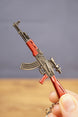 Red modded AKM rifle keychain close-up with optic, curved magazine and metallic finish, ideal gamer gift for FPS collectors
