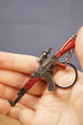Detailed red AKM-style rifle keyring held in hand with key loop attached, collectible accessory for airsoft and tactical gaming fans