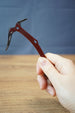 Red Rebel ice pick keyring replica held in hand with red handle, silver pick, black grip, and detailed miniature collectible design.