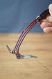 Handheld Red Rebel ice pick keyring replica inspired by Tarkov, showing the curved red handle, black grip, and silver pick detail.