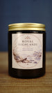 Royal Highlands vegan soy wax candle in an amber glass jar with gold lid, featuring a fresh sea salt and driftwood coastal fragrance.