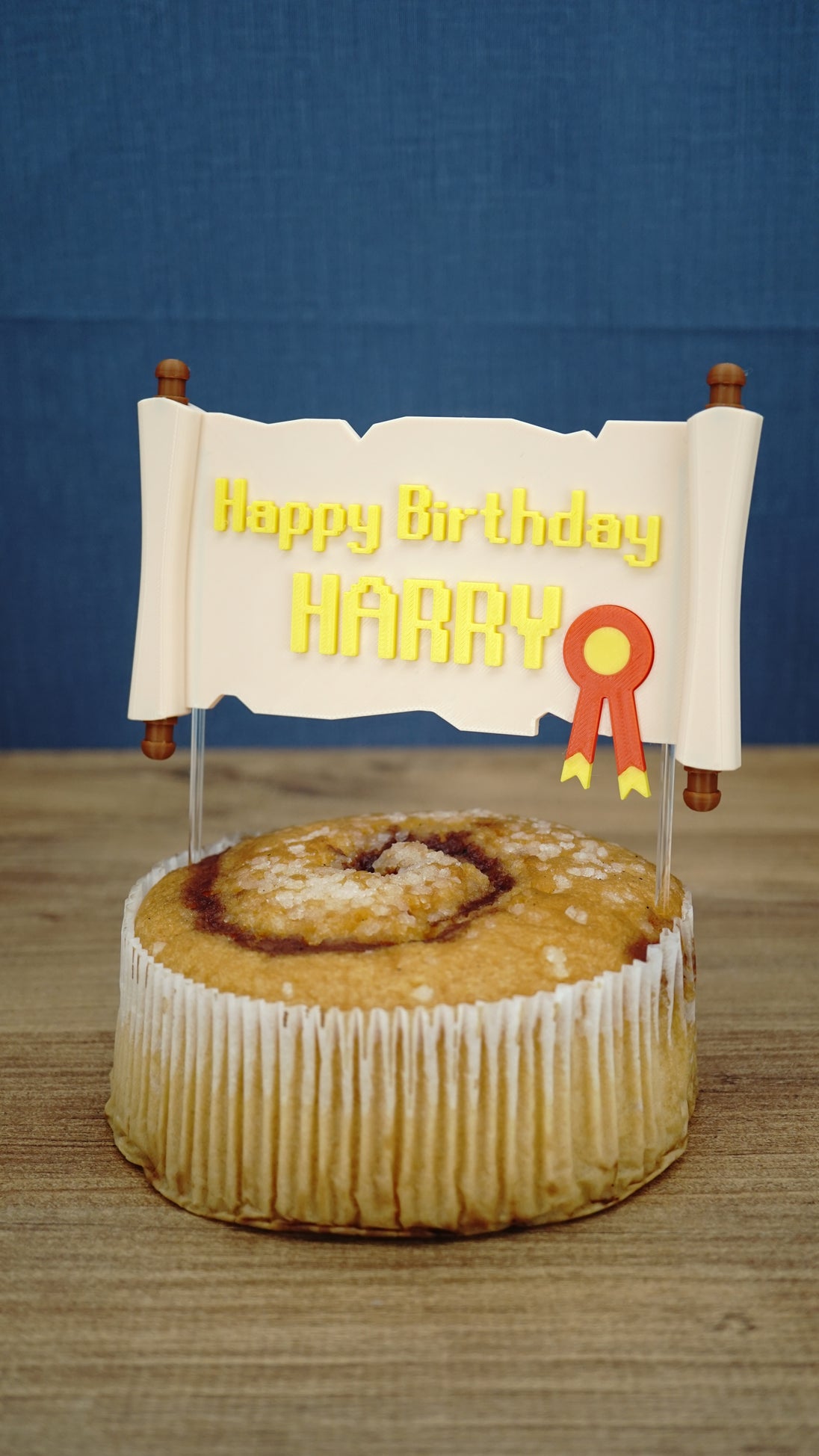 Personalised RuneScape-inspired scroll cake topper displayed on a cake, featuring yellow Happy Birthday Harry text and fantasy party styling.
