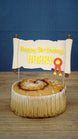 Personalised RuneScape-inspired scroll cake topper displayed on a cake, featuring yellow Happy Birthday Harry text and fantasy party styling.