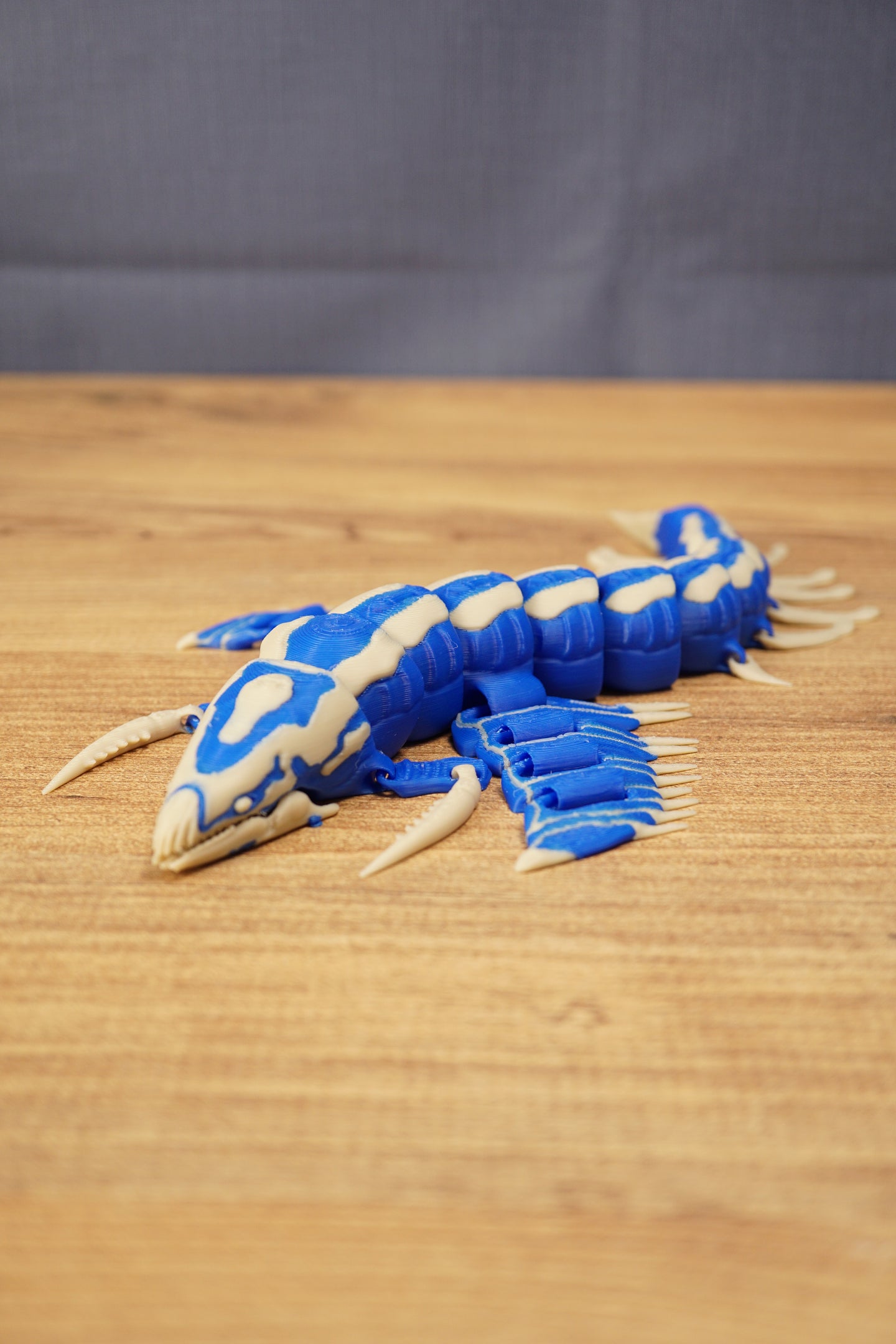 Shiver Leviathan articulated figure in blue and bone colours shown on a wooden surface with detailed segmented body and fins.