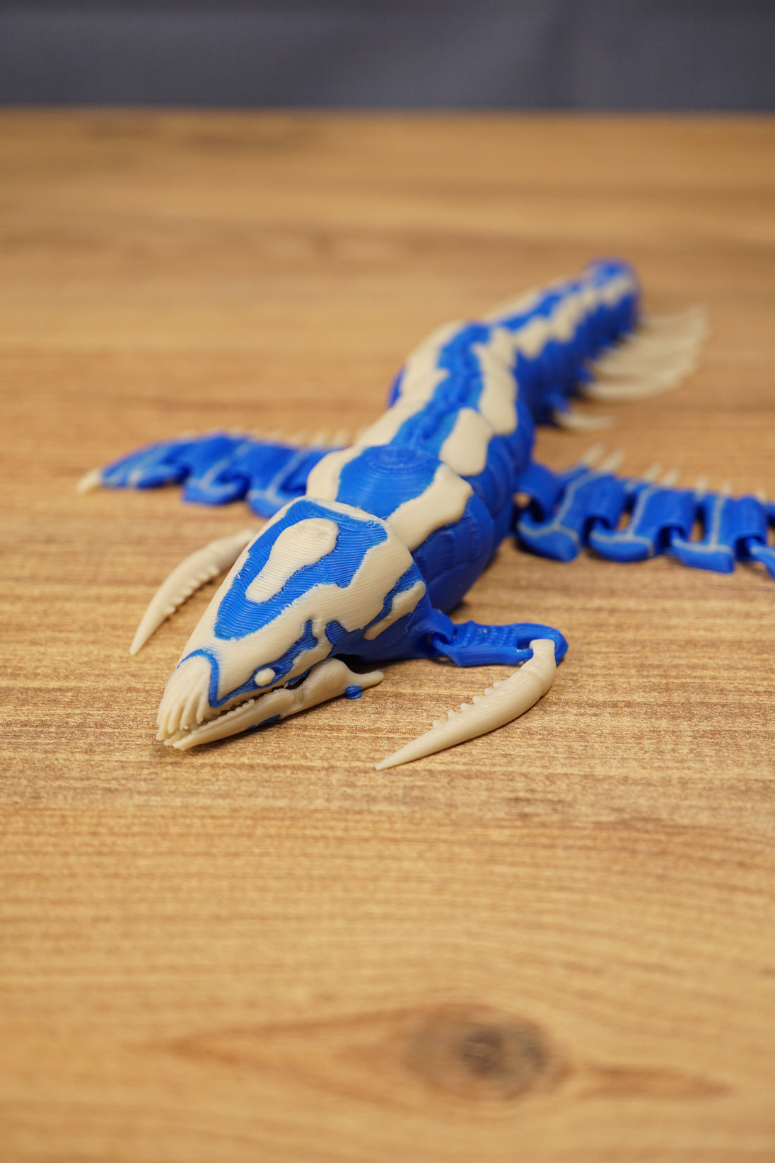 Close angled view of the Shiver Leviathan figure showing the detailed head, curved claws, blue body, and bone colour markings.
