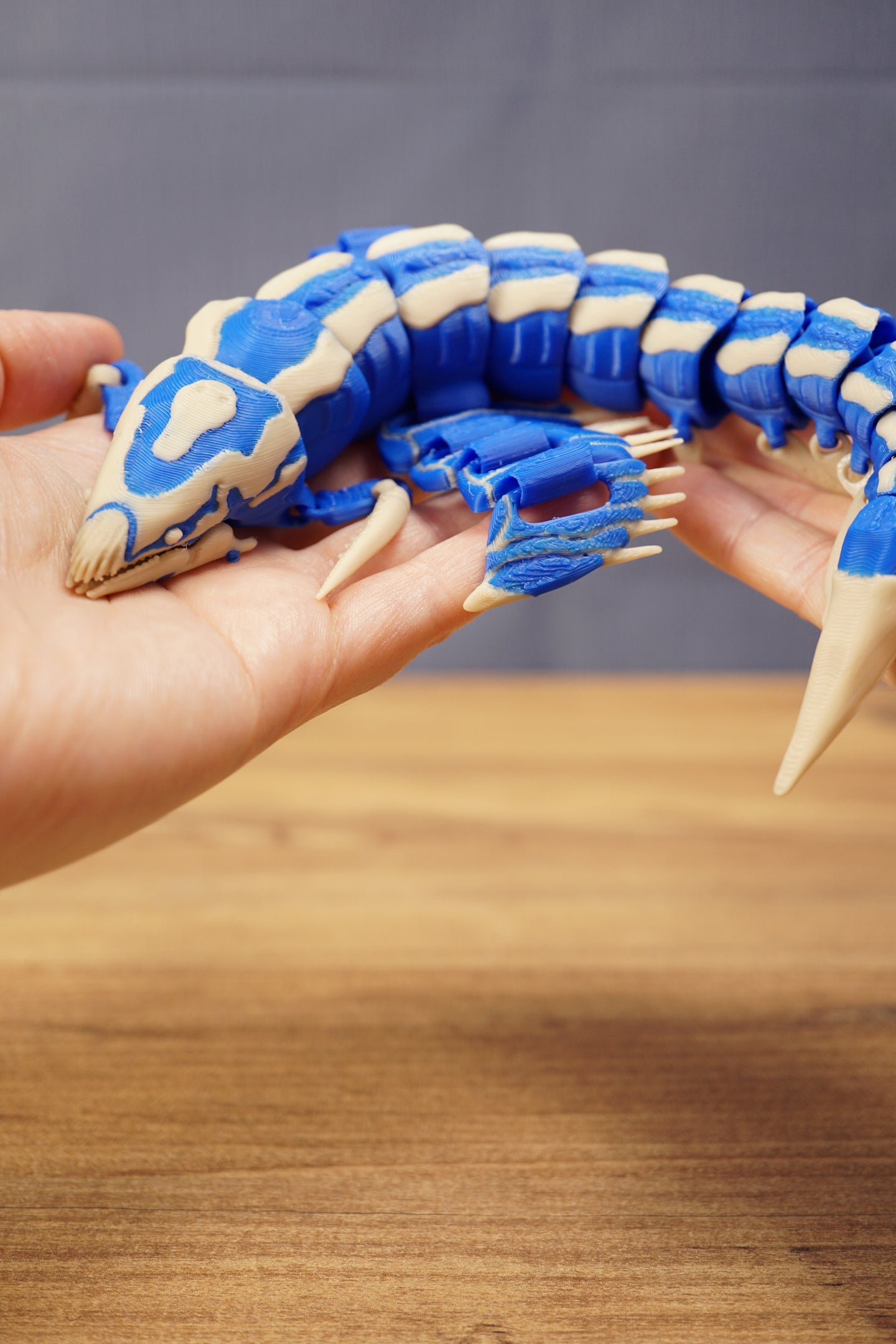 Flexible Shiver Leviathan figure curved in hand, highlighting the blue body, bone markings, fins, and poseable segmented design