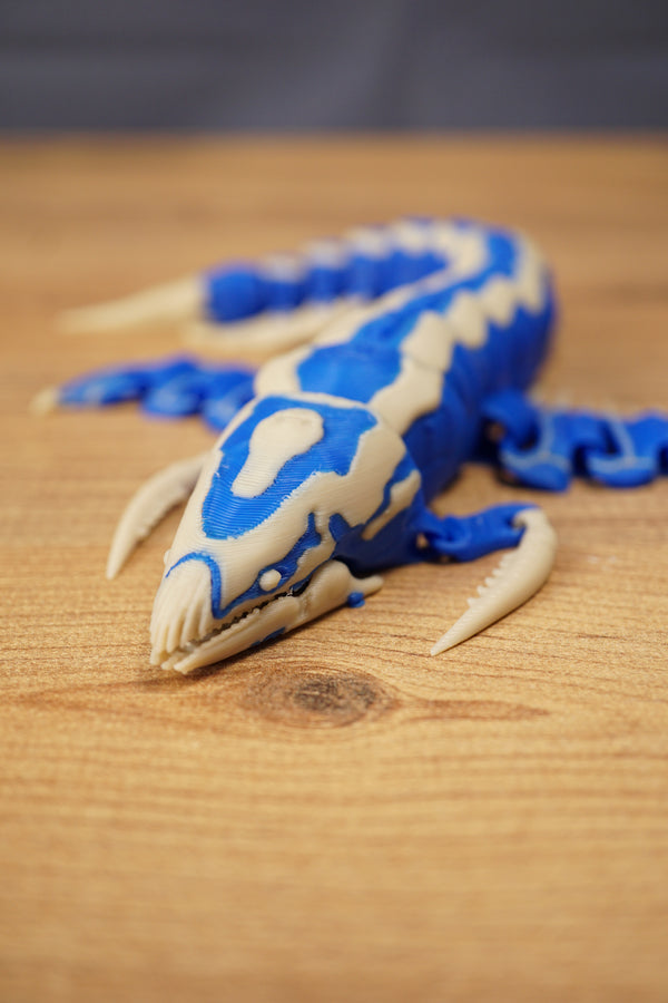 Front angled view of the Shiver Leviathan figure with open jaw, curved claw, blue body, and bone colour markings.