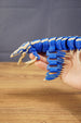 Side view of the Shiver Leviathan figure held in hand, showing articulated body segments, fins, claws, and long tail.