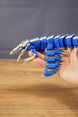 Side view of the Shiver Leviathan figure held in hand, showing articulated body segments, fins, claws, and long tail.