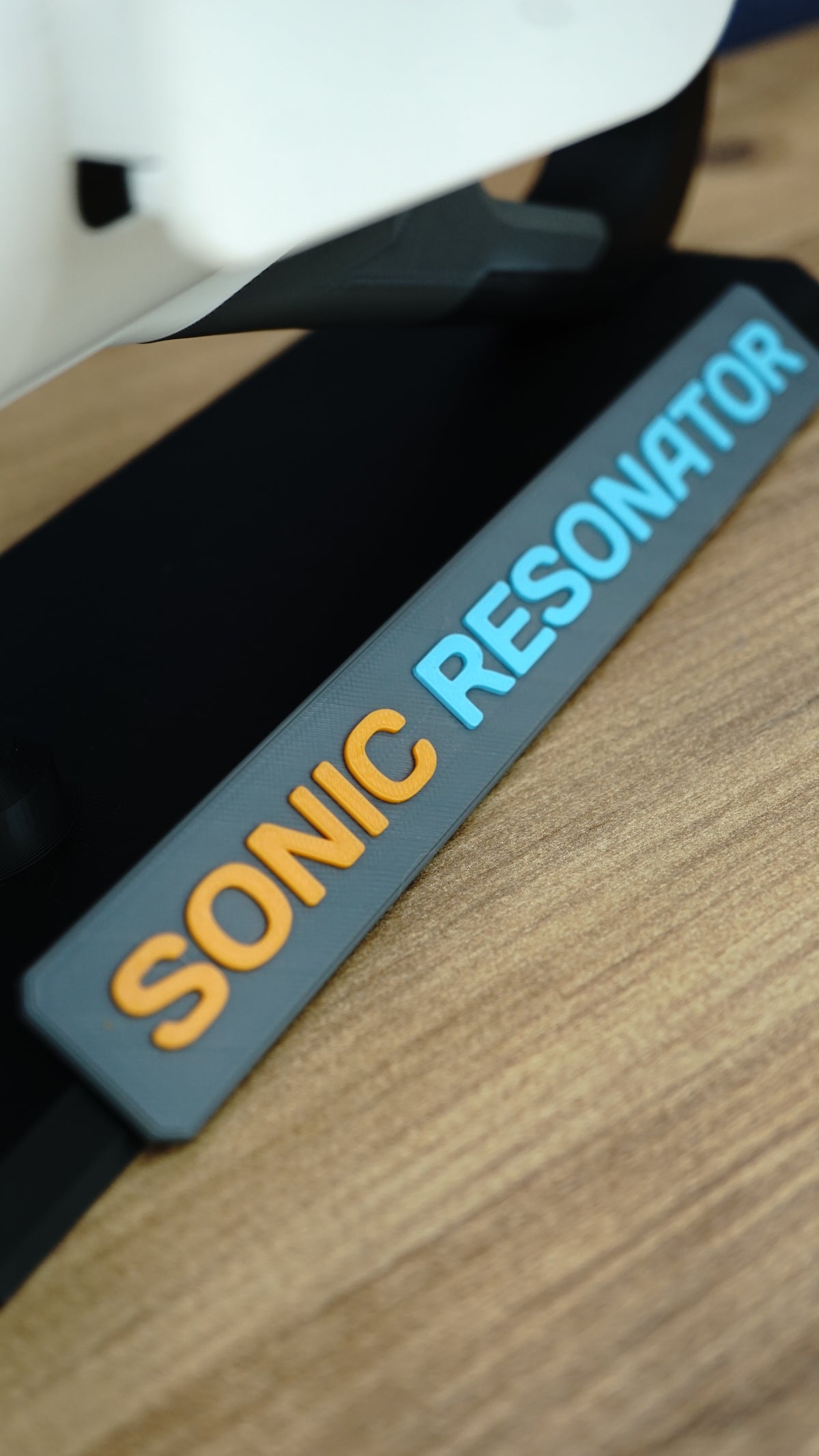 Close-up of Sonic Resonator display stand nameplate with raised orange and cyan lettering beneath the Subnautica 2 inspired collectible replica