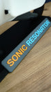Close-up of Sonic Resonator display stand nameplate with raised orange and cyan lettering beneath the Subnautica 2 inspired collectible replica