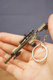 Detailed SR-25 tactical rifle keychain resting in hand with visible scope, magazine, stock, barrel, chain, and circular keyring attachment.