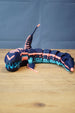 Full side view of articulated Marrowbreach inspired figure with segmented body, tall dorsal fin, dark blue shell and bright light blue underside.