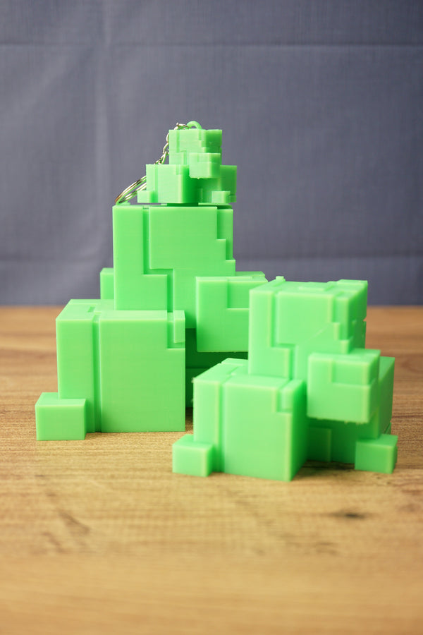 Subnautica inspired ion cube replica display with green cube collectibles, stacked block shapes, and a small matching keychain on top.