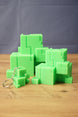 Subnautica ion cube replica set with bright green cube-style collectibles and matching keychain, displayed on a wooden tabletop.