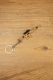 Angled tan MCX-SPEAR inspired rifle keyring with black optic detail and metal chain on wood, ideal gaming collectible gift