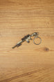 Angled SR-25 rifle keychain on wood with detailed scope, barrel, stock, magazine, and circular keyring for tactical shooter fans and collectors.