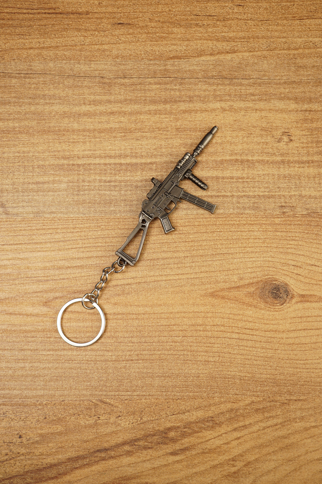 Angled view of a detailed UMP45-style tactical submachine gun keyring with metal chain, suppressor-style barrel and front grip
