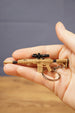 Tan tactical rifle keyring with black optic, stock and barrel details resting in hand, a compact collectible gift for shooter game fans