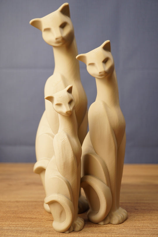 Set of three beige 3D printed cat figurines inspired by Tarkov, displayed together on a wooden tabletop with a grey backdrop.