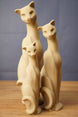 Set of three beige 3D printed cat figurines inspired by Tarkov, displayed together on a wooden tabletop with a grey backdrop.